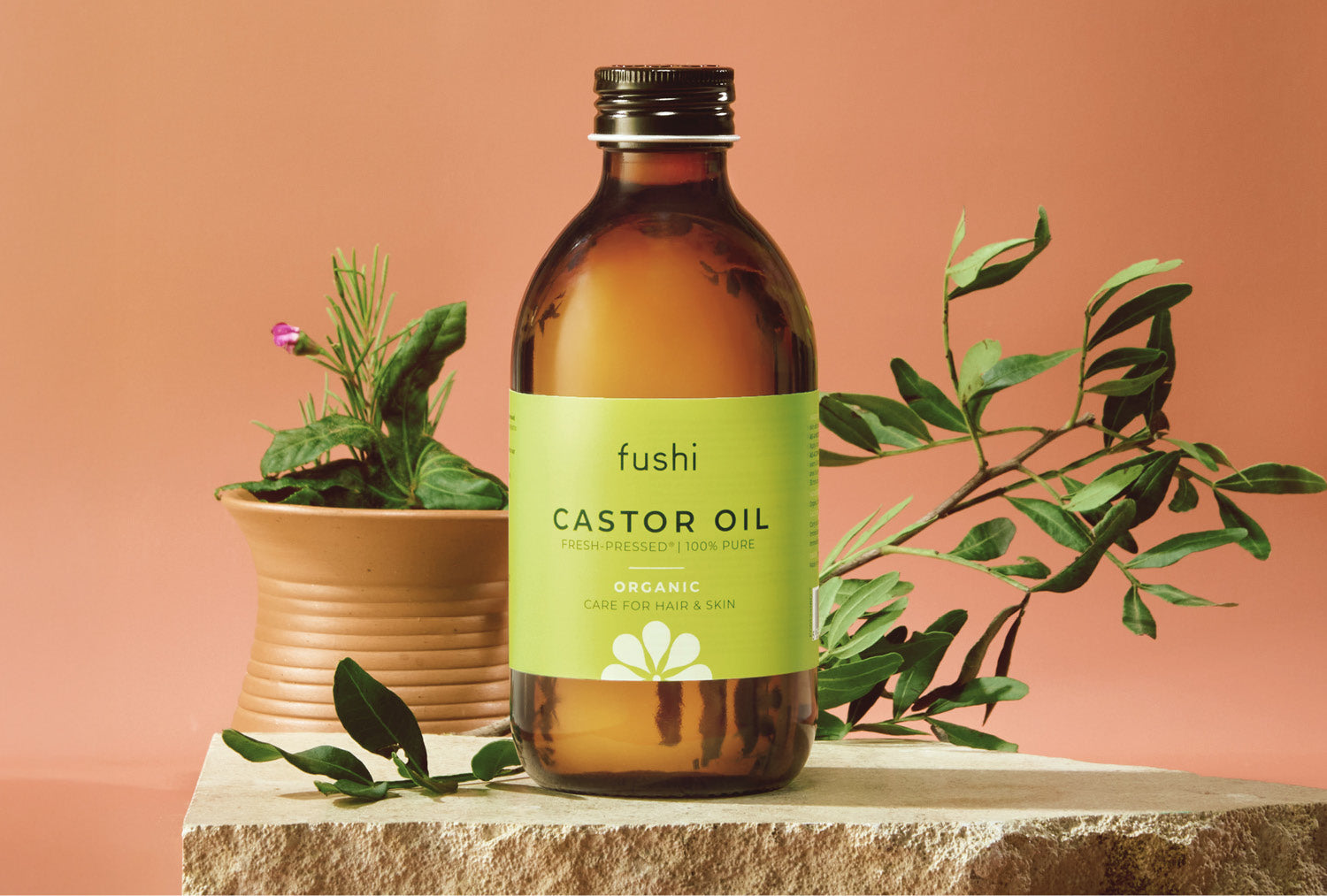 Image of Fushi organic cold pressed castor oil in amber bottle with herbs, ideal for Castor oil packs & lash conditioning.
